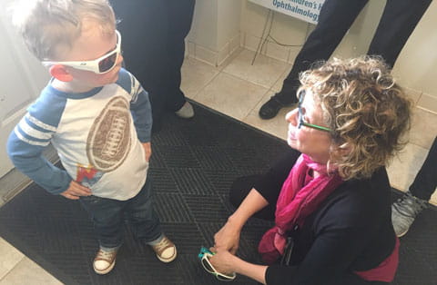 Pediatric Ophthalmologist Terry L. Schwartz, MD examines a patient's new sunglasses.